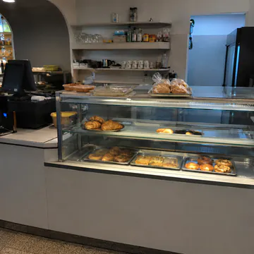 Mostrador de cafetería vacío, mal iluminado